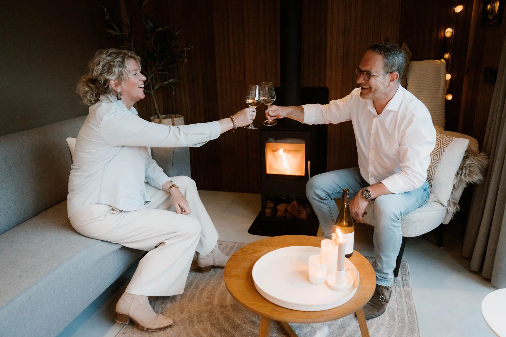 Interieur van tuinkamer met zithoek en houtkachel