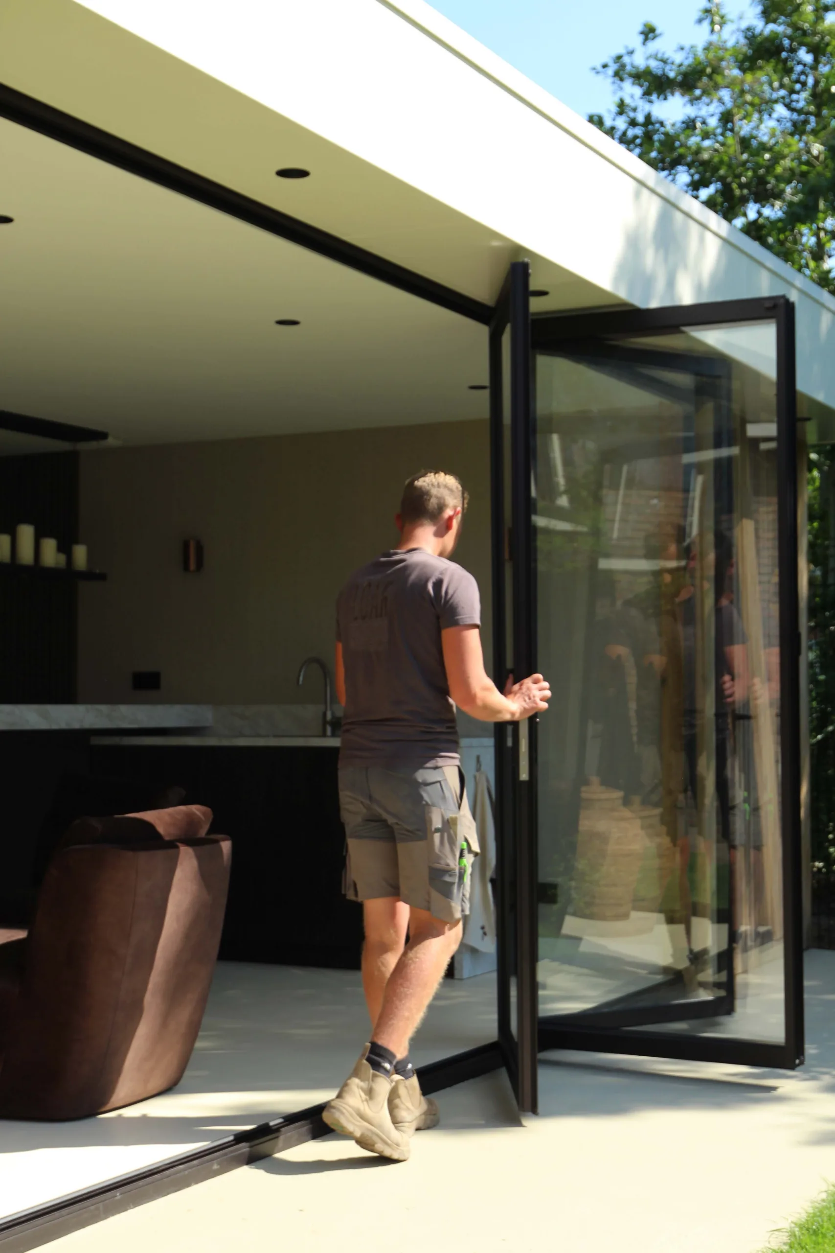 Geopende harmonicapui tussen luxe buitenverblijf en tuin